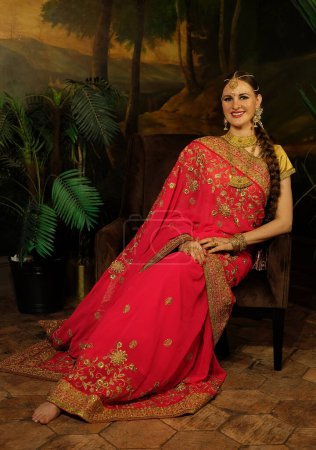 Foto de Retrato de una hermosa hembra india. Joven mujer hindú modelo Kundan joyas. Traje indio tradicional saree rojo. - Imagen libre de derechos