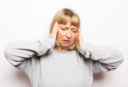 Photo for Lifestyle, health and old people concept: Beautiful mature woman touching her head having a headache, on white background - Royalty Free Image