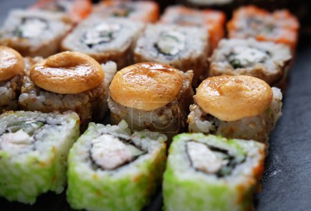 Téléchargez les photos : De la nourriture japonaise. Des sushi. Rouleau de Philadelphie avec saumon frais, concombre, avocat, fromage à la crème, caviar tobiko. Gros plan. - en image libre de droit
