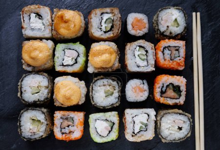 Photo for Japanese food. Sushi. Philadelphia roll with fresh salmon, cucumber, avocado, cream cheese, tobiko caviar. Close up. - Royalty Free Image