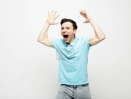 Photo for Young man wearing blue t-shirt celebrating victory over grey background - Royalty Free Image