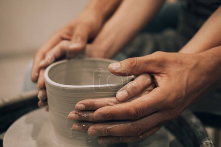 Foto de Couple mold ceramic vase in a pottery workshop, hands close up. Hobby concept. - Imagen libre de derechos