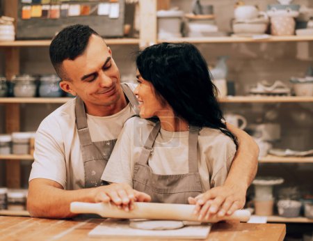 Téléchargez les photos : A young lovely couple works in a pottery workshop. The concept of hobbies, lifestyle and relationships. - en image libre de droit