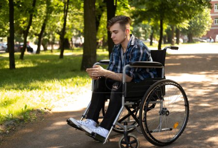 Photo for Young disabled man in wheelchair walking park and listening music, lifestyle concept. - Royalty Free Image