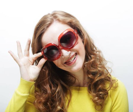 Foto de Funny young curly woman wearing big sunglasses over white background - Imagen libre de derechos