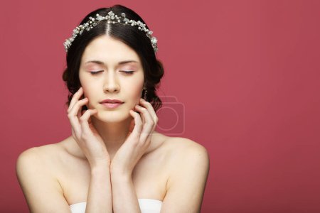 Foto de Hermosa novia joven con peinado de boda de moda. Retrato de mujer joven sobre fondo rosa. - Imagen libre de derechos