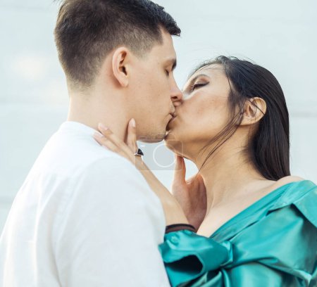 Téléchargez les photos : Young happy couple in love of different nationality hugging and kissingnear river. Asian woman and european man. - en image libre de droit