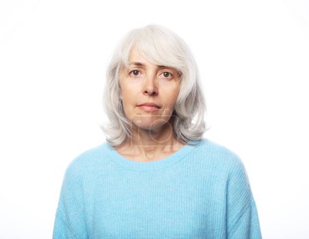 Photo for Happy elderly female wearing blue sweater smiling over white background, close up - Royalty Free Image
