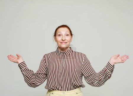 Photo for Lifestyle, emotion and old people concept: senior surprised woman in striped shirt. Isolated over grey background. - Royalty Free Image