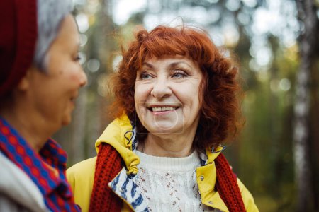 Photo for Lifestyle, emotion and female friendship concept. Cheerful pensioner female friends tallking and laughing in the autumn park. - Royalty Free Image