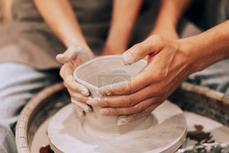 Téléchargez les photos : Couple moule vase en céramique dans un atelier de poterie, mains fermer. Le concept de passe-temps, mode de vie et relations. - en image libre de droit