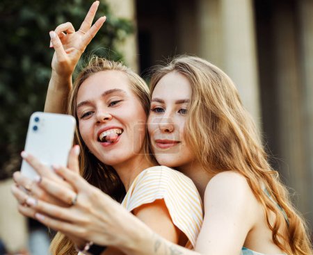 Téléchargez les photos : Deux jeunes femmes heureuses ensemble prenant un selfie dans la ville. Jour d'été. Concept d'amitié. Jeunes amies bonheur. - en image libre de droit