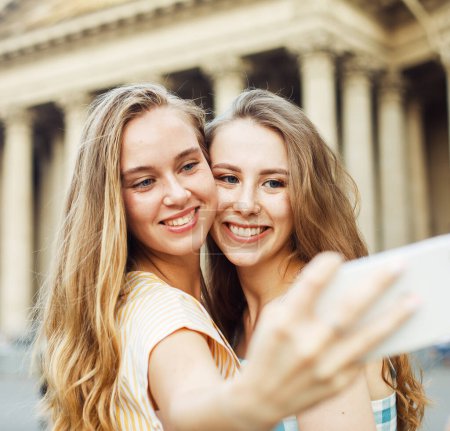 Téléchargez les photos : Deux jeunes femmes heureuses ensemble prenant un selfie dans la ville. Jour d'été. Concept d'amitié. Jeunes amies bonheur. - en image libre de droit