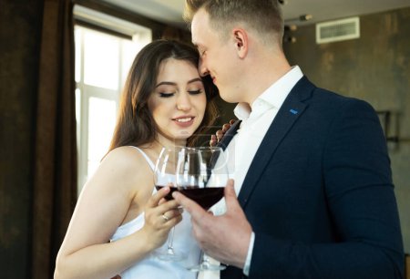 Foto de La novia y el novio sostienen en sus manos vasos con vino. Joven y feliz. - Imagen libre de derechos