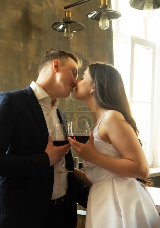 Téléchargez les photos : Concept de famille et de jeunes : Jeunes mariés buvant du vin et souriant à leur bonheur, romance et tendresse - en image libre de droit