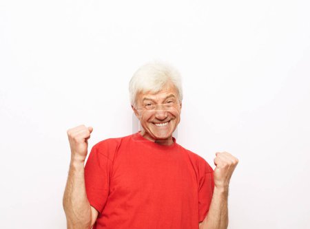 Téléchargez les photos : Homme âgé portant un t-shirt rouge sur fond isolé faisant des pouces heureux geste avec les mains. Approuver l'expression en regardant la caméra avec succès. - en image libre de droit