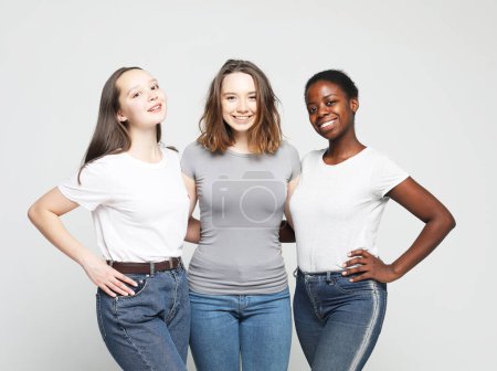 Photo for Group of happy young women of different size and ethnicity in t-shirts over light grey background - Royalty Free Image