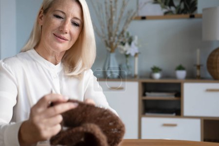 Téléchargez les photos : Woman Senior Adult Knitting Concept - Elderly blond woman holding knitting needles. Time for hobby. - en image libre de droit