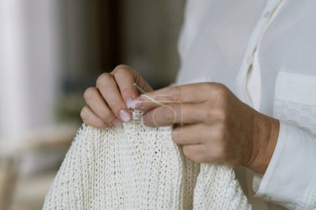 Téléchargez les photos : Les mains de la femme tricot motif de fil de laine brune. Photo horizontale rapprochée. Freelance concept d'artisanat créatif, passe-temps et mode de vie - en image libre de droit