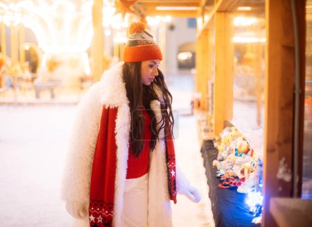 Téléchargez les photos : Charmante jeune femme au marché de Noël à côté de l'arbre du Nouvel An. Heure d'hiver. - en image libre de droit
