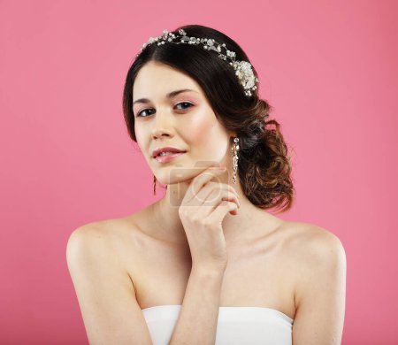 Téléchargez les photos : Beautiful young bride with fashion wedding hairstyle. Portrait of young woman over pink background. - en image libre de droit