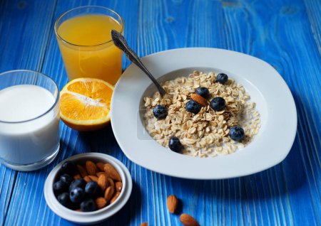Photo for Healthy breakfast, food and diet concept - oatmeal with fresh berries on white plate with orange juice and milk, close up - Royalty Free Image