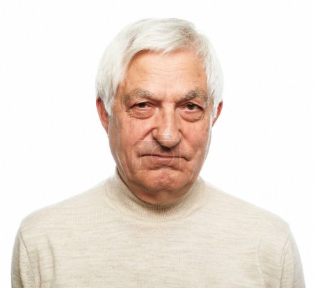 Foto de Hombre mayor con el pelo gris frunce el ceño y se ve disgustado sobre el fondo blanco. De cerca.. - Imagen libre de derechos