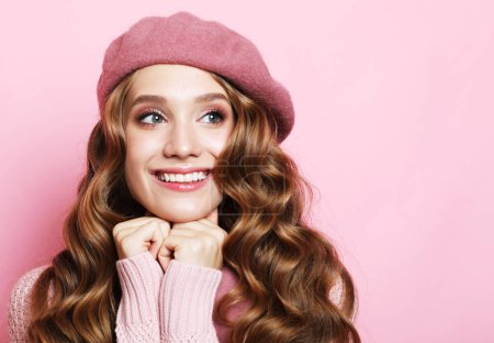 Photo for Beautiful young woman with long wavy hair wearing pink beret over pink background - Royalty Free Image