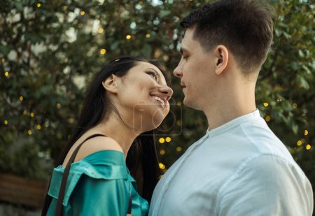 Foto de Joven pareja feliz enamorada de diferente nacionalidad abrazándose en el parque. Mujer asiática y hombre europeo. Día de verano. - Imagen libre de derechos