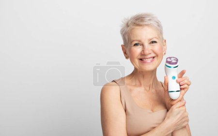 Téléchargez les photos : Belle femme des années 60 tenant un masseur dans sa main. Technique de spa annonces soins de la peau. - en image libre de droit