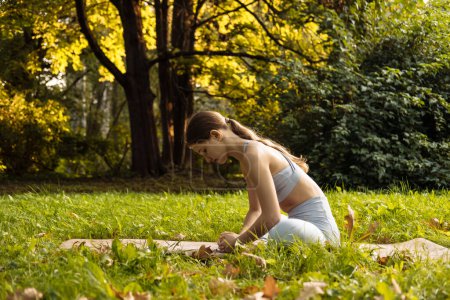 Photo for Young blond woman doing yoga exercise outdoor in the summer park, sport yoga concept - Royalty Free Image