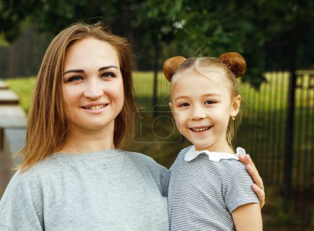 Téléchargez les photos : Portrait d'une petite fille heureuse avec sa mère dans le parc. Bonne journée d'été. Jouer avec les enfants et le concept d'une famille heureuse. - en image libre de droit