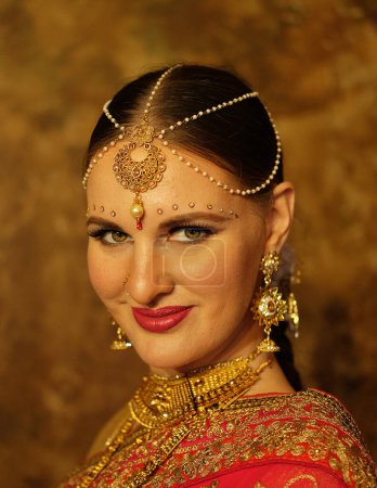 Foto de Hermosa mujer india en vestido de sari tradicional mirando bindi cámara en la frente, de cerca - Imagen libre de derechos