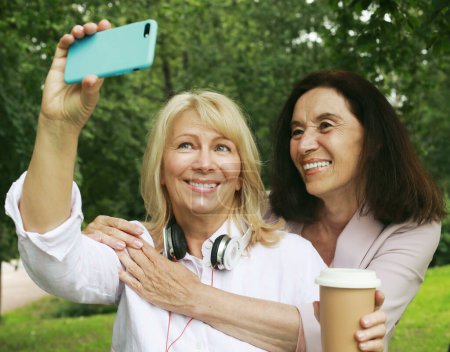 Photo for Two cheerful old women making selfie in summer park. Lifestyle concept. - Royalty Free Image