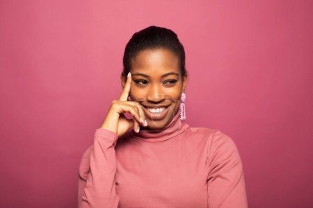 Foto de Joven hermosa mujer afroamericana sonriendo ampliamente sobre fondo rosa - Imagen libre de derechos