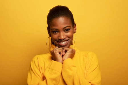 Foto de Estilo de vida, emoción y concepto de personas: primer plano retrato de una hermosa joven africana riéndose sobre un fondo amarillo - Imagen libre de derechos
