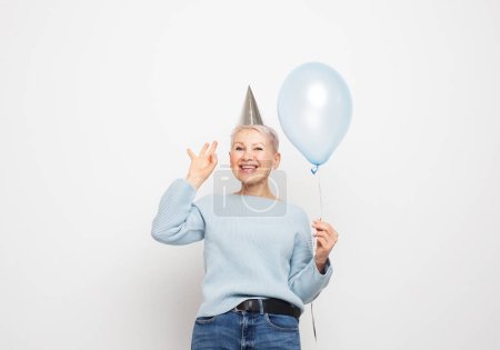 Photo for Portrait of her she nice-looking attractive lovely overjoyed cheerful cheery gray-haired lady holding blue balloon having fun isolated on white grey color background - Royalty Free Image