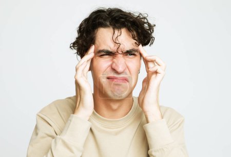 Photo for Young brunette man suffering of strong headache - Royalty Free Image