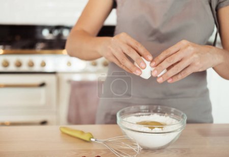 Foto de Primer plano manos femeninas romper un huevo en harina, concepto de alimentos. - Imagen libre de derechos
