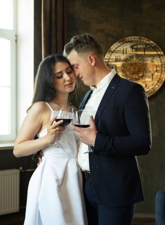 Foto de Joven pareja recién casada bebiendo vino y sonriendo a su felicidad, romance y ternura - Imagen libre de derechos