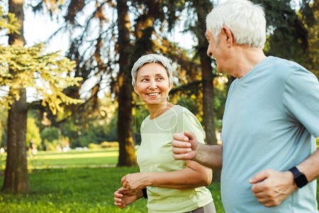 Photo for Smiling senior couple jogging in the park. Lifestyle, people and sport concept. - Royalty Free Image