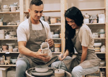 Foto de Una pareja joven se dedica a la creatividad en un taller de cerámica. Concepto de estilo de vida y hobby. - Imagen libre de derechos