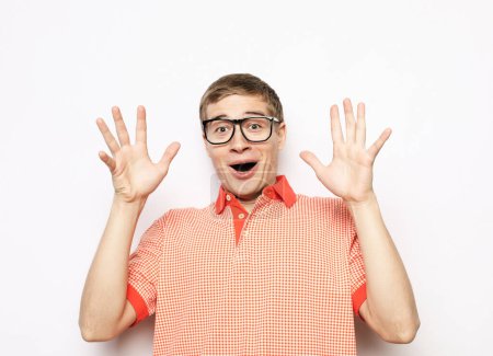 Téléchargez les photos : Jeune bel homme portant des lunettes avec des émotions surprises sur son visage un fond gris - en image libre de droit