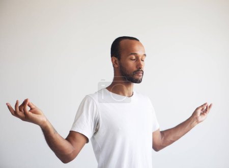 Foto de Joven hombre afro guapo concentrando su mente, meditando, yoga ejercicio respiración técnica reducir el estrés. - Imagen libre de derechos