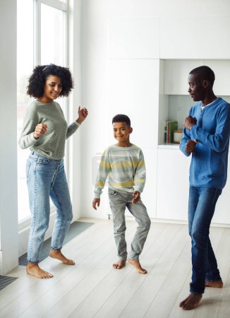 Foto de Alegre familia afroamericana - mamá, papá e hijo bailando en casa. Felices juntos. Estilo de vida y concepto familiar. - Imagen libre de derechos