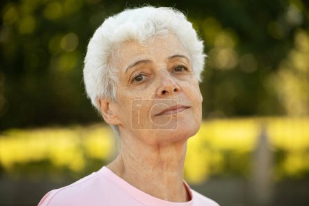 Photo for Pretty elderly woman smiling in the summer park - Royalty Free Image