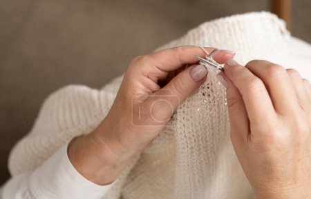 Foto de Las manos de la mujer tejiendo patrón de hilo de lana blanca. Primer plano de imagen. - Imagen libre de derechos