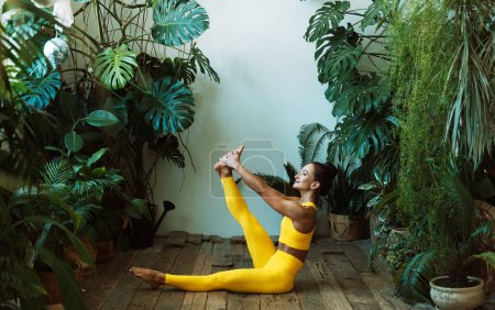 Téléchargez les photos : Une femme adulte pratique le yoga dans la jungle urbaine. Femme en yoga asanas et Pilates à la maison. - en image libre de droit