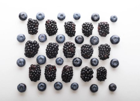 Mix berries patern over white background. Blackberries and blueberries. Close up.