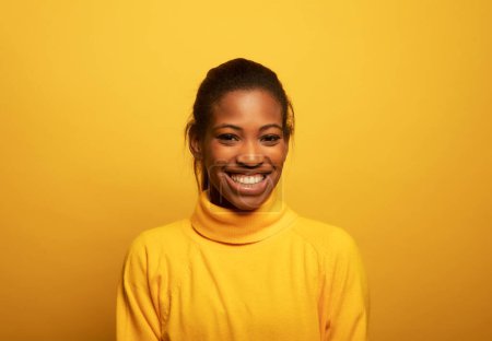 Téléchargez les photos : Gros plan portrait de belle jeune femme africaine riant sur fond jaune, style de vie et concept de personnes. - en image libre de droit